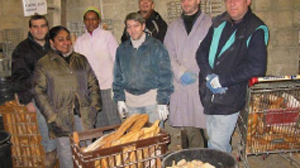 ceci est une photo, plusieurs personne sont dans un local devant divers contenant de pain