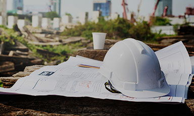batiment-second-oeuvre ceci est la photo d'un casque de chantier d'un plan et d'un gobelet posé au sol dans une friche industriel